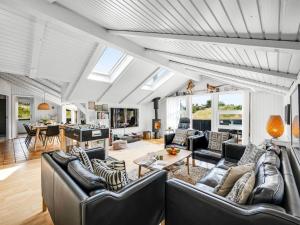 a living room with leather couches and a table at Holiday Home Emin - 700m from the sea by Interhome in Vejers Strand