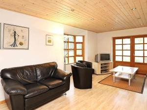 a living room with a leather couch and a table at 8 person holiday home in Læsø in Læsø