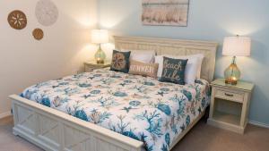 a bedroom with a bed with blue and white sheets and pillows at Tranquil Turquoise Retreat home in South Padre Island
