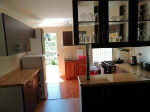 a kitchen with wooden cabinets and a kitchen with a refrigerator at Pucón, casa en parcela in Pucón
