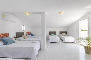 three beds in a room with white walls at My Private Space Villa by Fidalsa in Derramador +22 photos