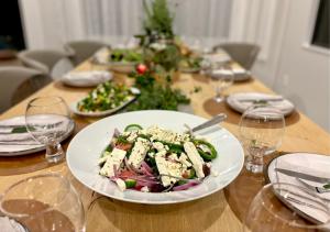 a table with a plate of salad and a christmas tree at Supreme on Marine - Beachfront! in Mount Maunganui