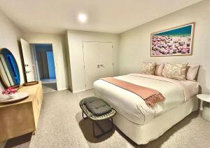 a bedroom with a large bed and a bathroom at Supreme on Marine - Beachfront! in Mount Maunganui