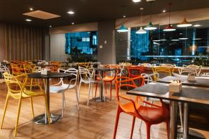 a restaurant with tables and chairs in a room at Aéra São José Floripa in São José +27 photos