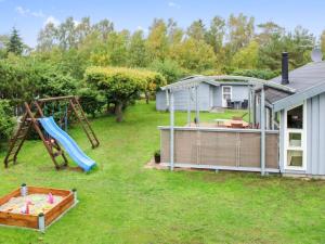 a yard with a playground and a house at Holiday Home Albertina - 200m from the sea by Interhome in Hals