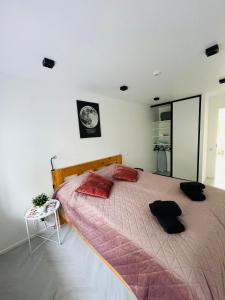 a bedroom with a large bed with red pillows at White Apartment in Liepāja