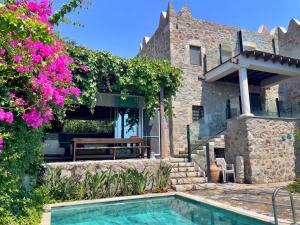 a house with a swimming pool and pink flowers at Private Pool Getaway in a Luxury Stone Villa in Bodrum City