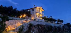 a house with stairs leading up to it at night at ADRIANA'S House KARDAMYLI PROSILIO in Prosílion