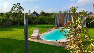 a swimming pool in a yard with two chairs and a pole at Olly House in Glebovka