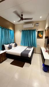a bedroom with a bed and blue curtains at Greenapple Residency in Chennai
