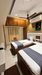 a hotel room with two beds and a tv at Greenapple Residency in Chennai