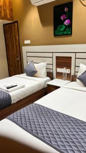 two beds in a hotel room with two beds at Greenapple Residency in Chennai +6 photos