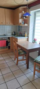 a kitchen with a wooden table and a table and chairs at Deichblick in Tespe