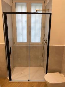 a glass shower with a toilet in a bathroom at Fronte Reggia Apartment in Caserta +11 photos