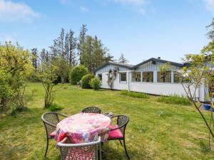 a table and chairs in the yard of a house at Holiday Home Lenard - 400m from the sea by Interhome in Hals