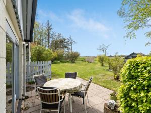 a patio with a table and chairs and a fence at Holiday Home Lenard - 400m from the sea by Interhome in Hals