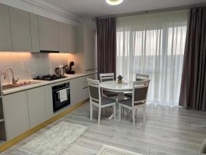 a kitchen and dining room with a table and chairs at Apartament Calea Bucovinei in Rădăuţi