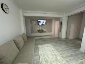 a living room with a couch and a tv at Apartament Calea Bucovinei in Rădăuţi