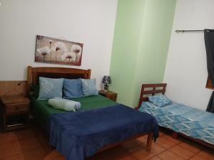 a bedroom with two beds with blue and green sheets at Helder ''DivinArt'' in Ribeira Grande