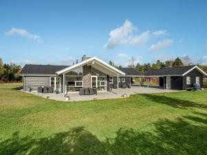 a house with dogs in front of a yard at Holiday Home Geri - 700m from the sea by Interhome in Hals