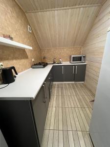 a kitchen with a white counter and a wooden ceiling at VULYK z MEDOM in Bukovel