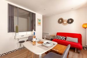 a living room with a red couch and a table at Joli appart dans les Rues Piétonnes in Sanary-sur-Mer