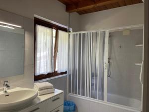 een badkamer met een wastafel en een douche bij Rifugio romantico per due in Pinzolo +26 foto's