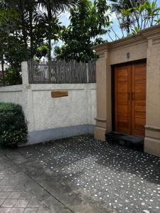a house with a wooden door and a fence at San Villa Canggu - 3BR Private Pool & Fast Wifi in Dalung