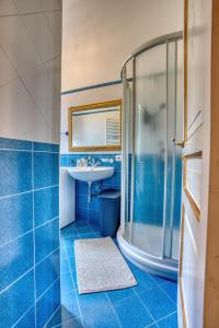 Un baño azul con lavabo y ducha. en La Baronessa Apartment near Pompei & Amalfi Coast, en Angri 43 fotos más