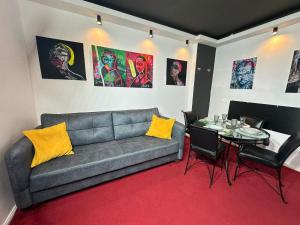 a living room with a couch and a table at Smarald - Premium Apt in Best Location & Parking in Craiova