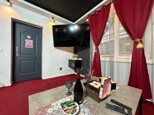 a room with a table with a bottle of wine at Smarald - Premium Apt in Best Location & Parking in Craiova