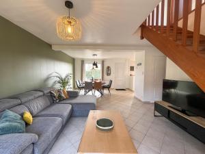 a living room with a couch and a table at Maison Belle Étoile à 5 min de la plage in Les Moitiers-dʼAllonne