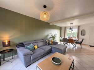 a living room with a couch and a table at Maison Belle Étoile à 5 min de la plage in Les Moitiers-dʼAllonne