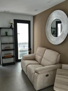 a living room with a couch and a mirror at WOWOLIDAYS Suite Love Ronda in Ronda