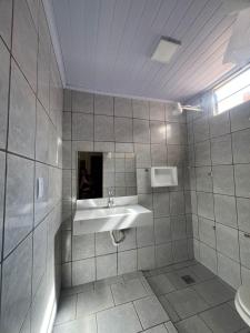 a bathroom with a sink and a mirror at Hotel Pinheiro in Unaí