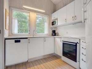 a white kitchen with white cabinets and a window at Holiday Home Selver - 250m from the sea by Interhome in Hals +14 photos