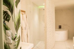 a white bathroom with a shower and a tub at Suite atypique, jacuzzi & Piscine 1 in Trévoux