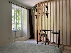 a bedroom with a staircase and a chair next to a window at Besançon: charmant duplex au pied de la citadelle in Besançon