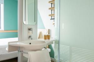 a bathroom with a sink and a mirror at ibis budget Toulouse Aeroport in Blagnac +80 photos