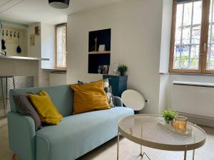 a living room with a blue couch and a table at Besançon: charmant duplex au pied de la citadelle in Besançon