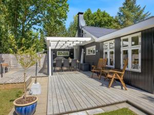 eine Holzterrasse mit Stühlen und ein Haus in der Unterkunft Holiday Home Marise - from the sea by Interhome in Hals + 16 Fotos