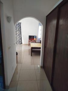 einen Flur mit einem Zimmer mit einem Bett und einem Tisch in der Unterkunft Villa meuble a louer Anakao in Anakao