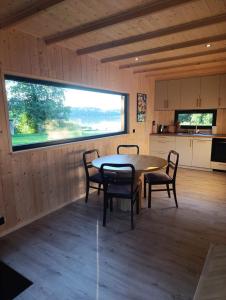 a dining room with a table and chairs and a window at Domek Pod Jemiołami - Mały Głęboczek in Mały Głęboczek