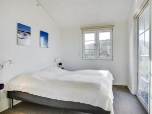 a white bedroom with a large bed and windows at Holiday Home Zaharinka - 300m from the sea by Interhome in Pandrup +10 photos