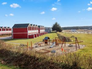 a playground in a field with red and white buildings at Apartment Hariett - 900m from the sea by Interhome in Løkken