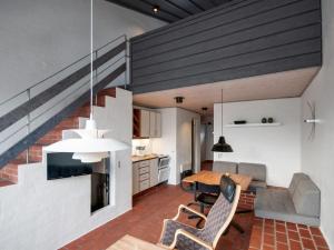 an open kitchen and living room with a dining table and chairs at Apartment Edisa - 50m from the sea by Interhome in Brovst