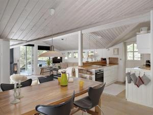 a kitchen and dining room with a table and chairs at Holiday Home Amabel - 200m from the sea by Interhome in Hals