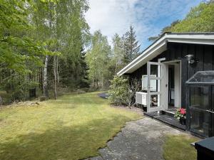 a small house with a yard next to a building at Holiday Home Amabel - 200m from the sea by Interhome in Hals