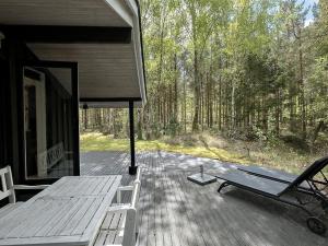 a porch of a cabin with a bench on a deck at Holiday Home Amabel - 200m from the sea by Interhome in Hals