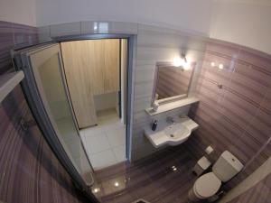a small bathroom with a sink and a mirror at Riviera Rooms in Himare